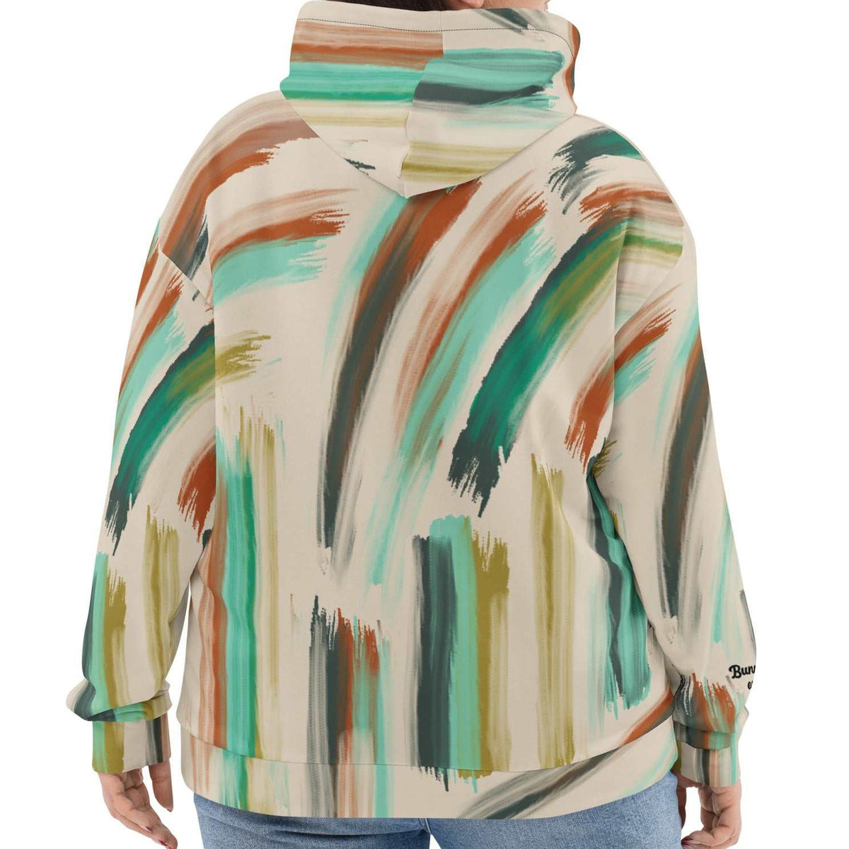 A model wearing The Artful Aura Hoodie, showing the relaxed, oversized fit and the soft pastel green brushstroke print on a beige background.