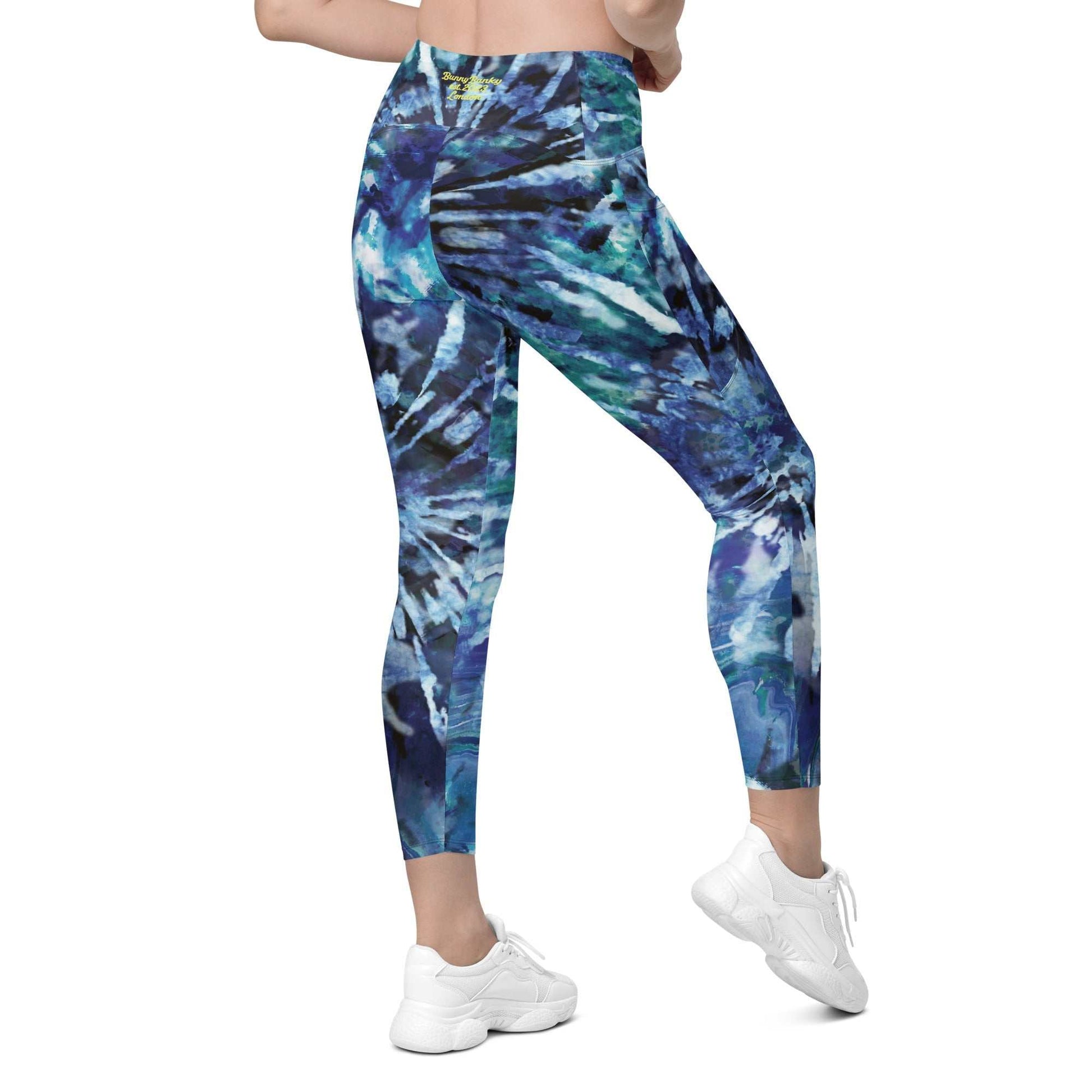 A model wearing The Athens Sculpt Leggings, showing the high-waisted, sculpting fit and the signature blue tie-dye print.