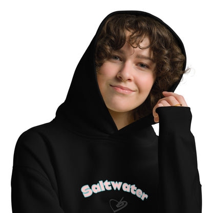 A model wearing The Azimuth Oversized Hoodie, showing the relaxed fit, drawstring hood, and "Saltwater Soul" text arched around the heart logo on the chest.