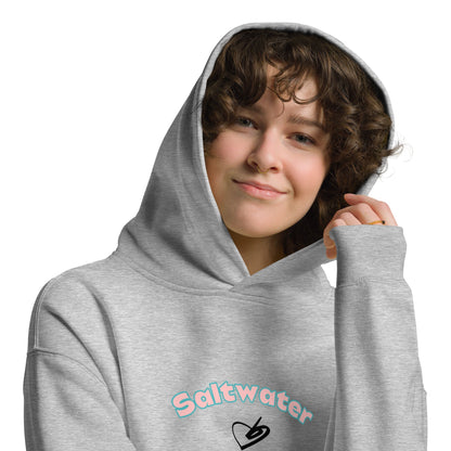 A model wearing The Azimuth Oversized Hoodie, showing the relaxed fit, drawstring hood, and "Saltwater Soul" text arched around the heart logo on the chest.