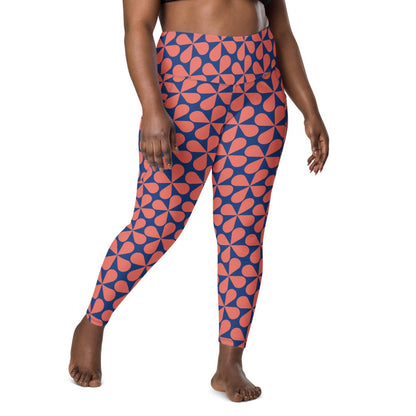 Model wearing the  Bakerloo Sculpt Leggings in geometric pattern in blue with coral background.