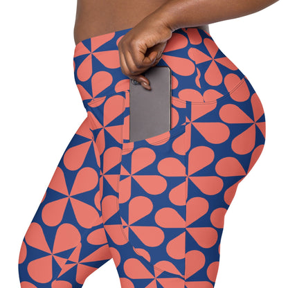 Model wearing the  Bakerloo Sculpt Leggings in geometric pattern in blue with coral background.