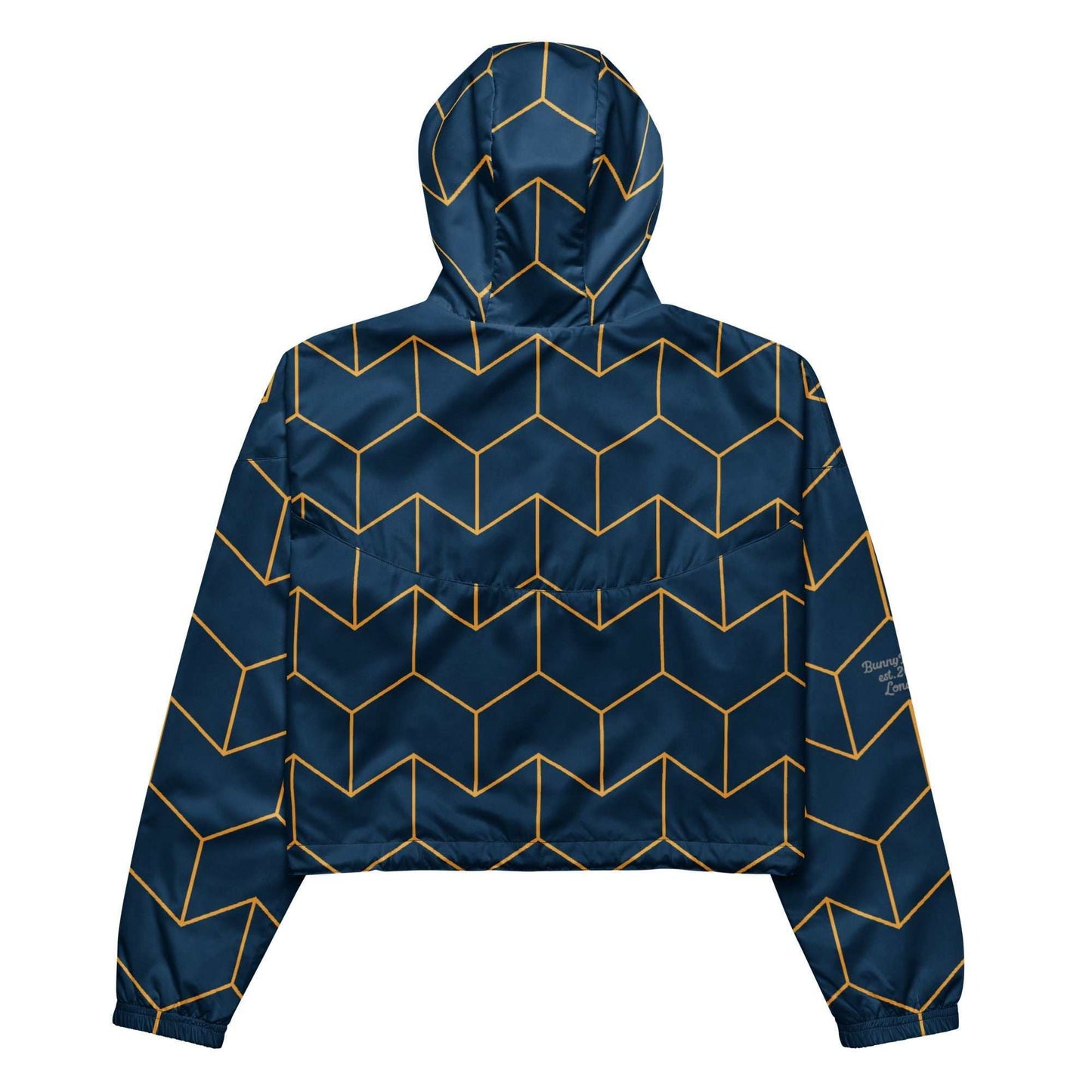 A close-up of The Baron's Court Windbreaker's navy blue and yellow Art Deco print, showing the recycled technical fabric, zip, and quality stitching.