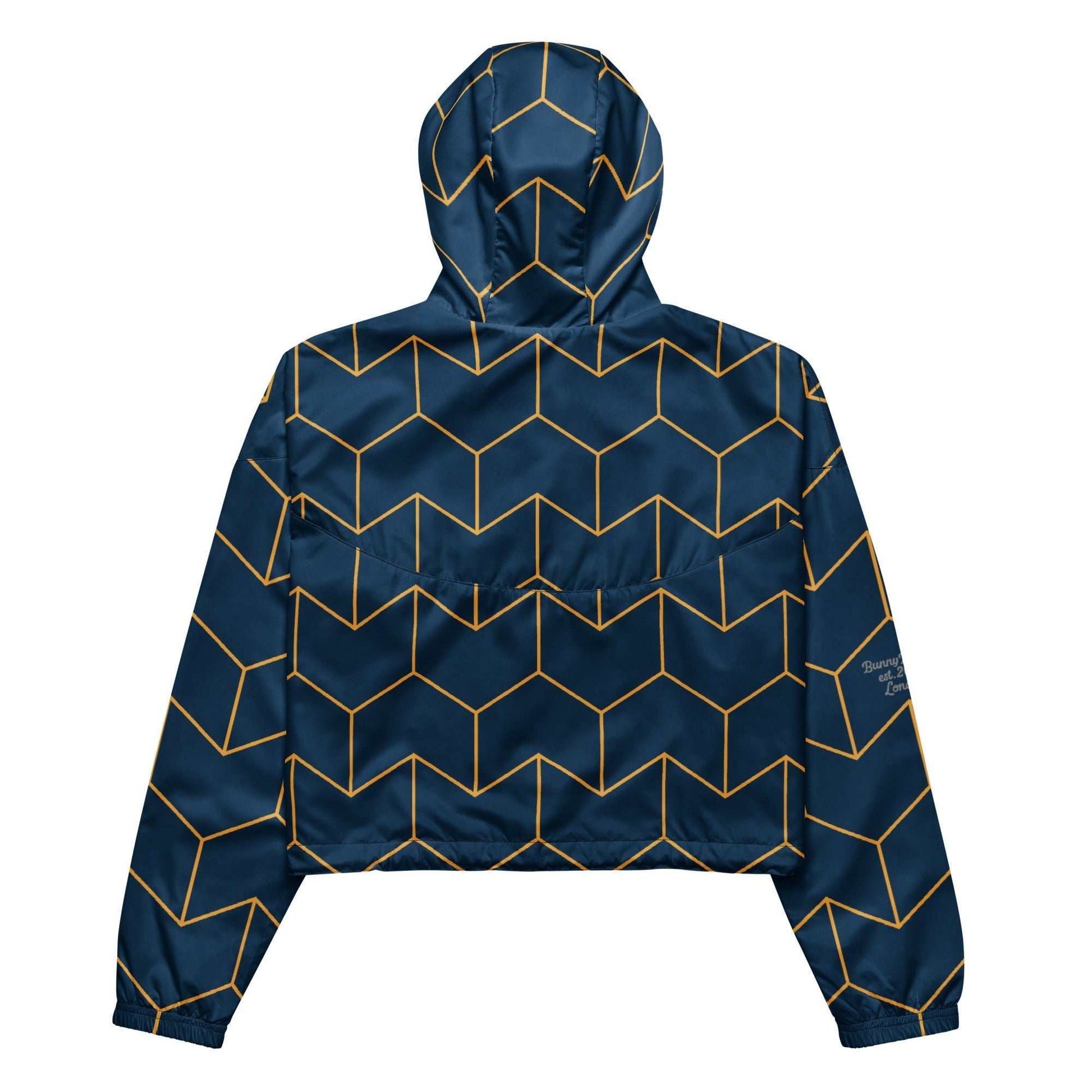 A close-up of The Baron's Court Windbreaker's navy blue and yellow Art Deco print, showing the recycled technical fabric, zip, and quality stitching.