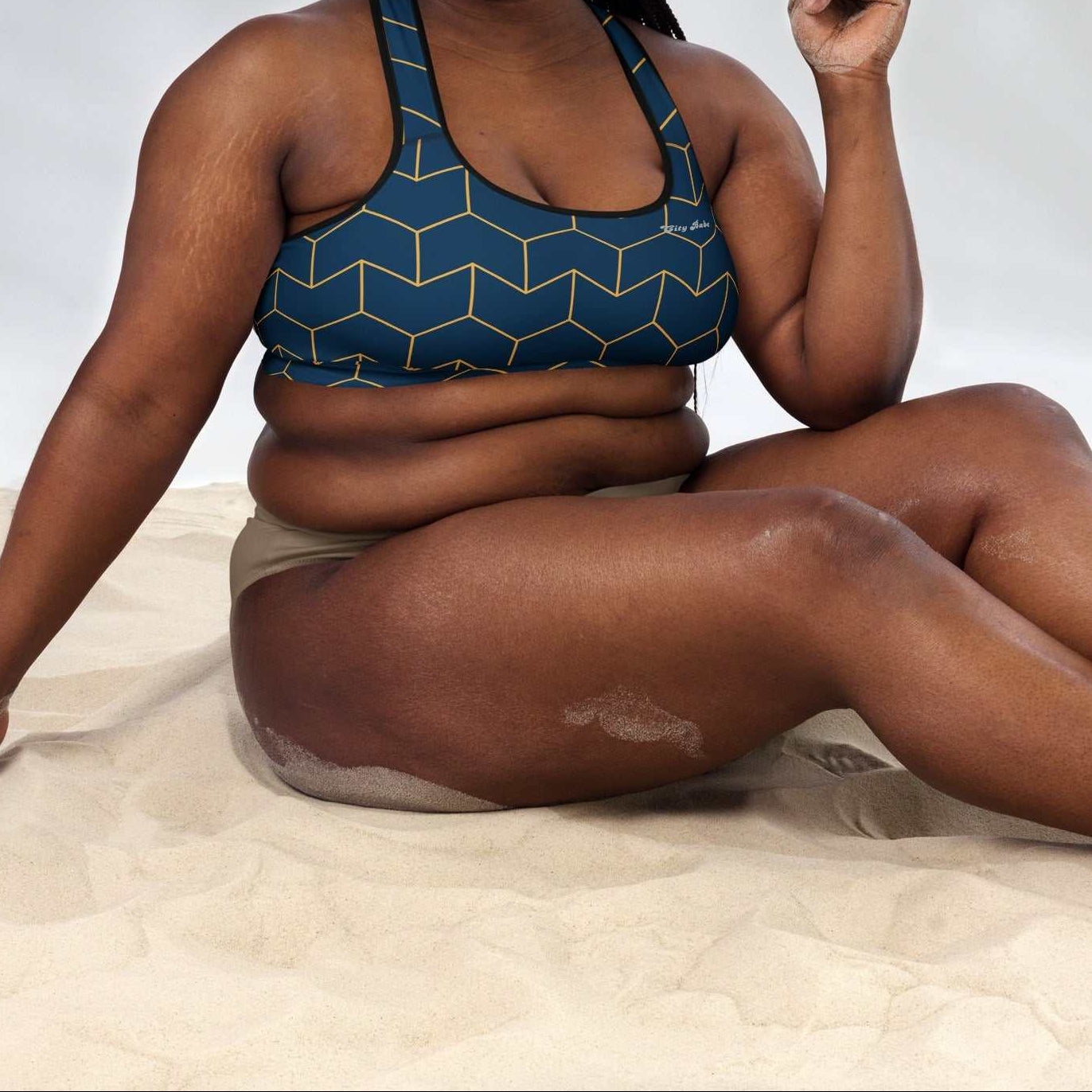 A model wearing The Barons Court Performance Bra, showing the supportive fit and the signature navy blue and yellow Art Deco print.