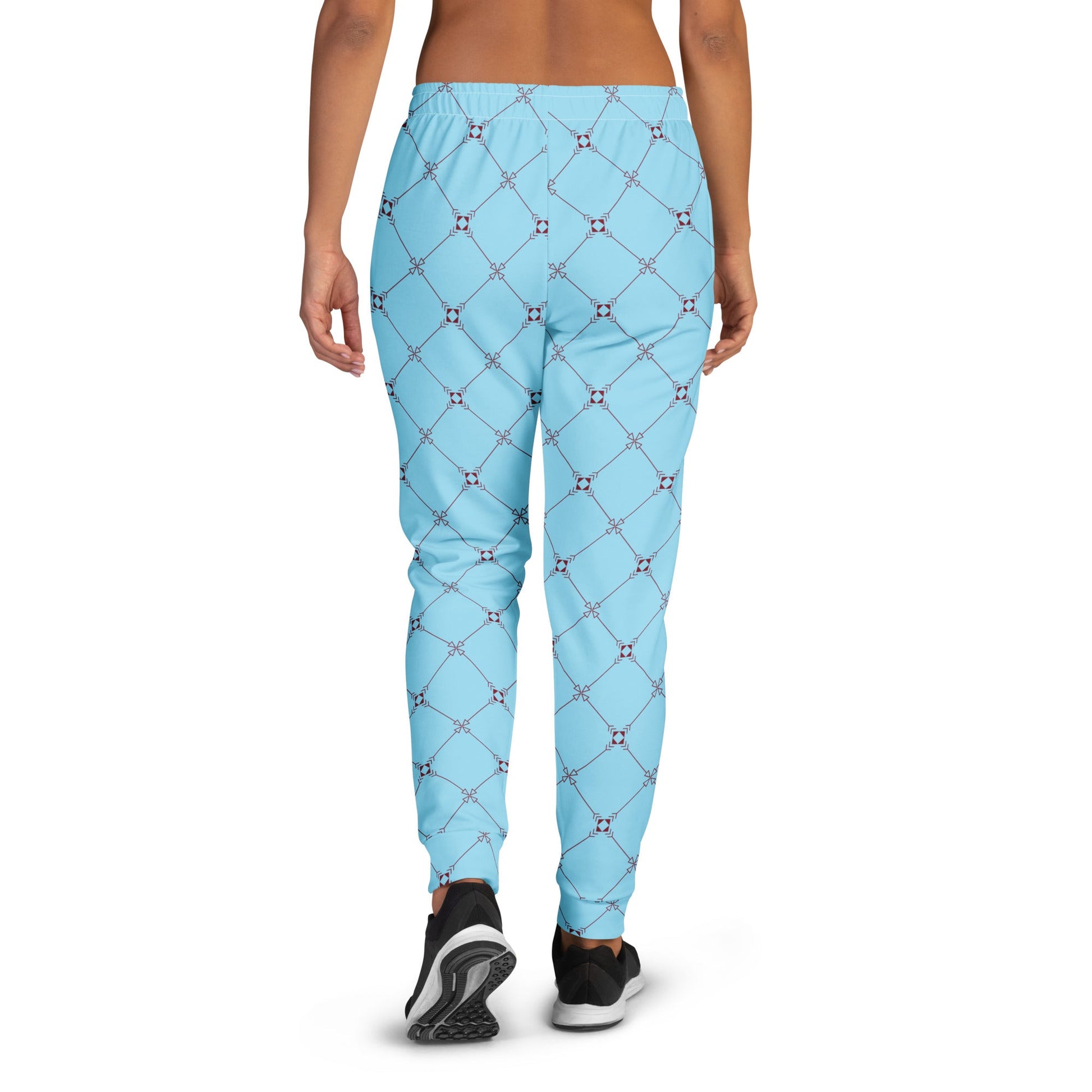 A model wearing the Belgravia Slim Fit Joggers in the burgundy monogram print, showing the tailored fit against the light blue background.