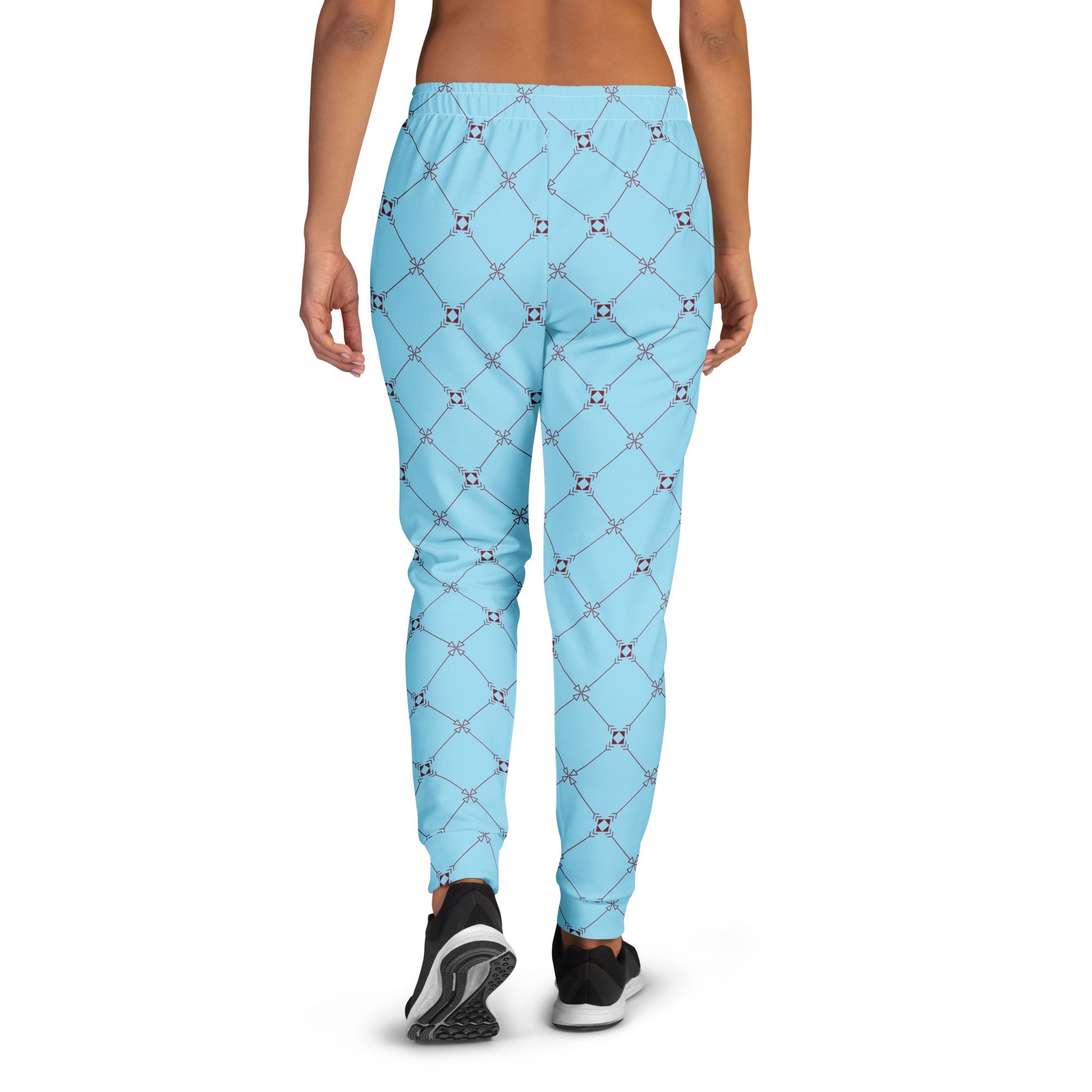 A model wearing the Belgravia Slim Fit Joggers in the burgundy monogram print, showing the tailored fit against the light blue background.