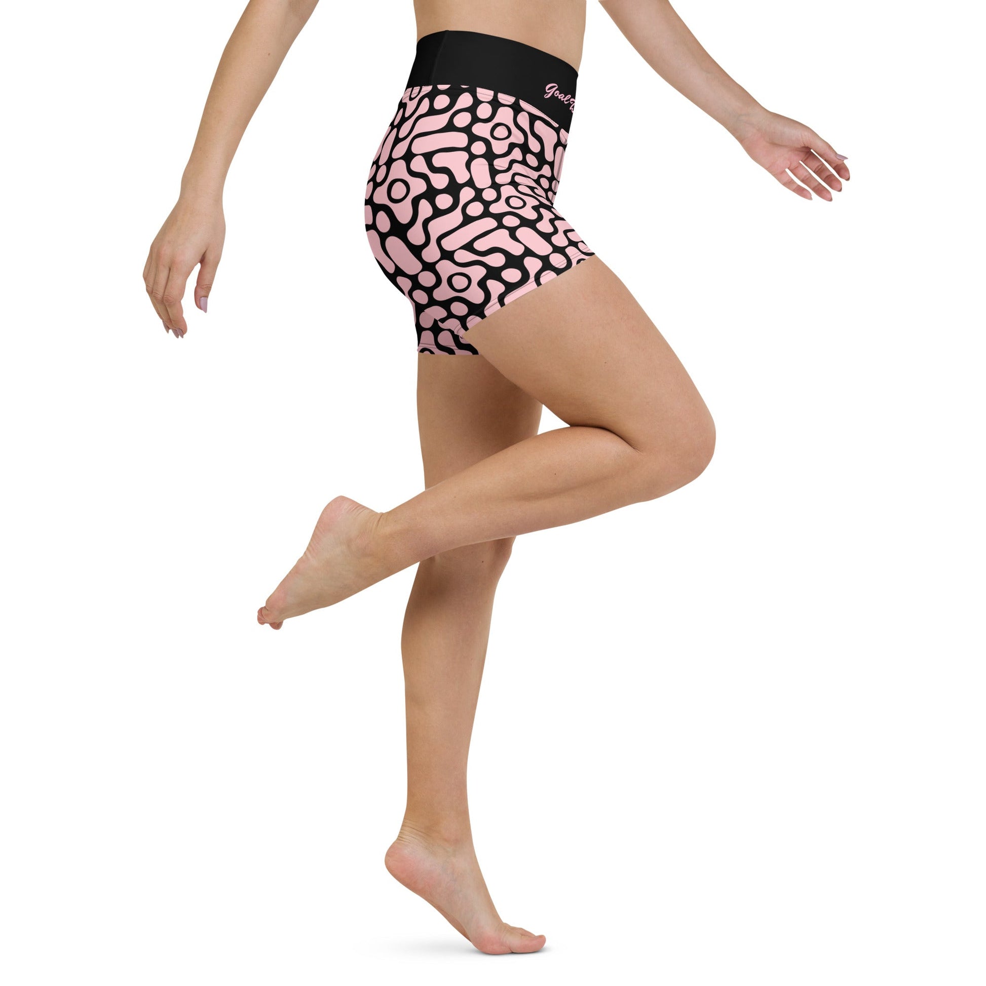 A close-up front view of BunnyBanky performance shorts featuring a bold, custom-designed geometric black floral pattern on a soft pink base. The high-waisted black compression waistband prominently displays the text "GOAL DIGGER" in a stylised, matching pink font. The shorts are designed for a snug, performance fit, shown here as part of a coordinated athletic set against a solid pink studio background.