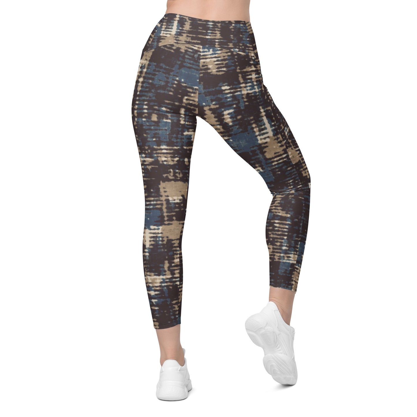 A model wearing the Chamonix Sculpt Leggings. A high-waisted leggings with an abstract brushstroke pattern in blue, beige, and dark brown, paired with white sneakers, shown against a plain white background.