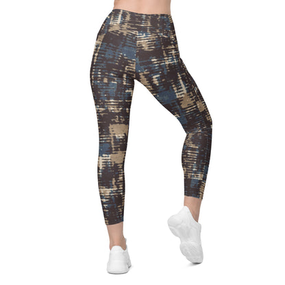 A model wearing the Chamonix Sculpt Leggings. A high-waisted leggings with an abstract brushstroke pattern in blue, beige, and dark brown, paired with white sneakers, shown against a plain white background.