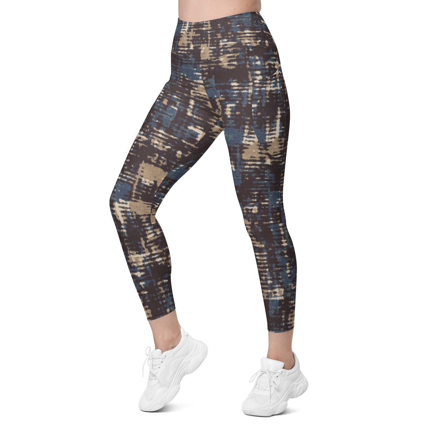 A model wearing the Chamonix Sculpt Leggings. A high-waisted leggings with an abstract brushstroke pattern in blue, beige, and dark brown, paired with white sneakers, shown against a plain white background.