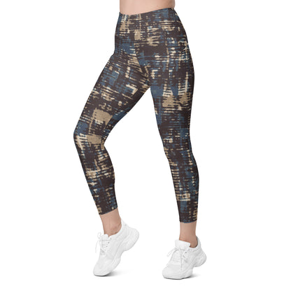 A model wearing the Chamonix Sculpt Leggings. A high-waisted leggings with an abstract brushstroke pattern in blue, beige, and dark brown, paired with white sneakers, shown against a plain white background.
