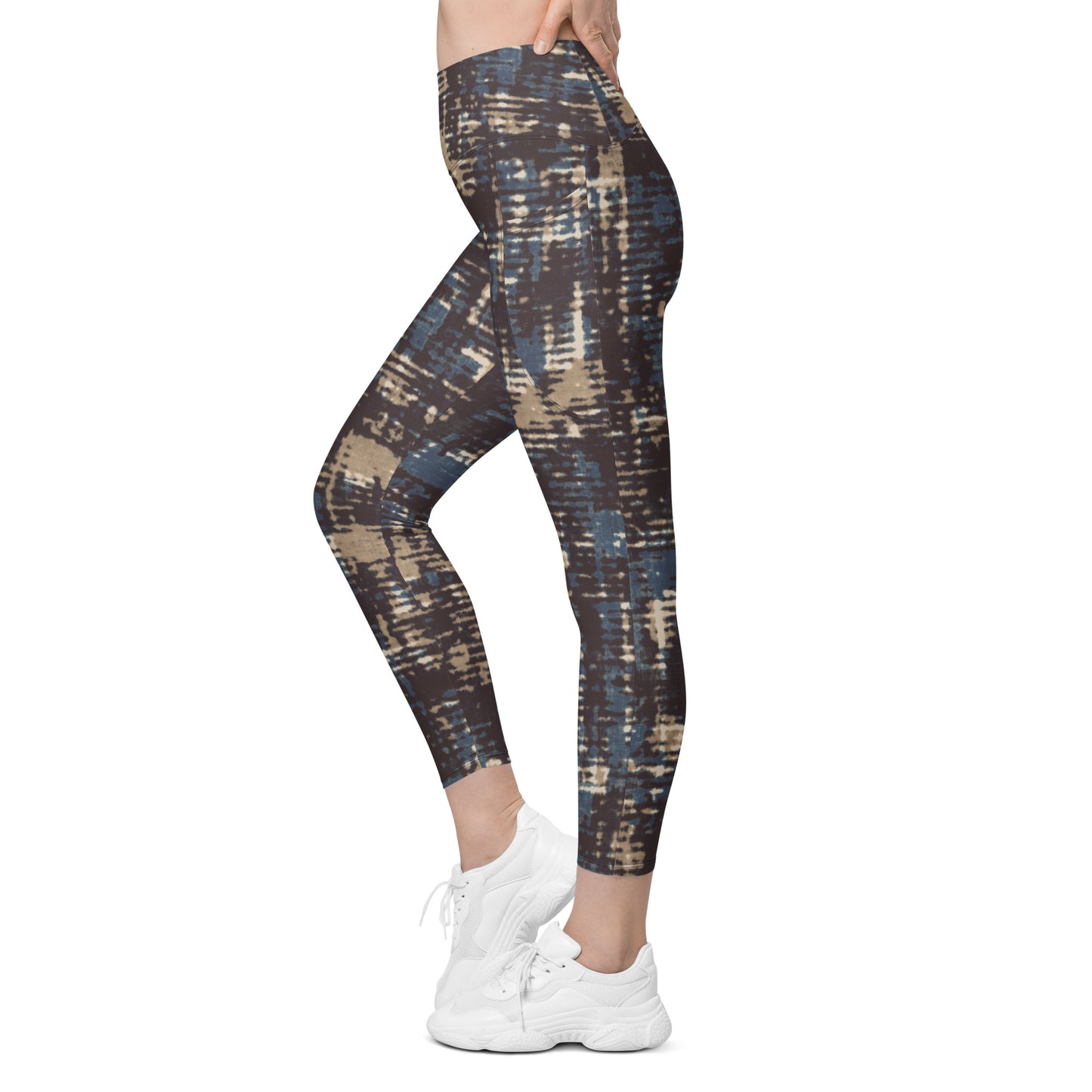 A model wearing the Chamonix Sculpt Leggings. A high-waisted leggings with an abstract brushstroke pattern in blue, beige, and dark brown, paired with white sneakers, shown against a plain white background.