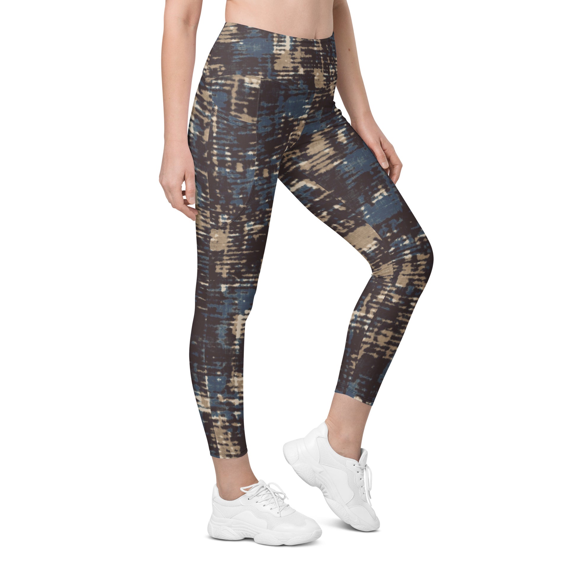 A model wearing the Chamonix Sculpt Leggings. A high-waisted leggings with an abstract brushstroke pattern in blue, beige, and dark brown, paired with white sneakers, shown against a plain white background.