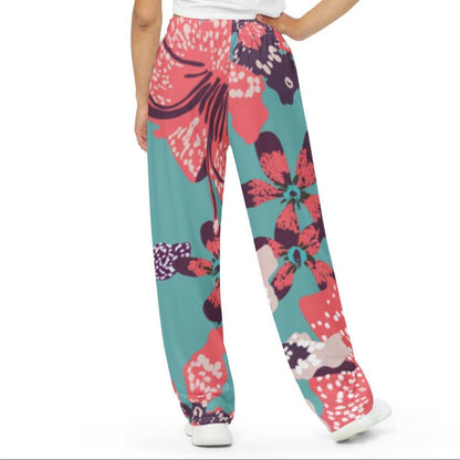Model wearing the Chelsea Flow Joggers featuring  a tropical print and  heritage logo against a white background.