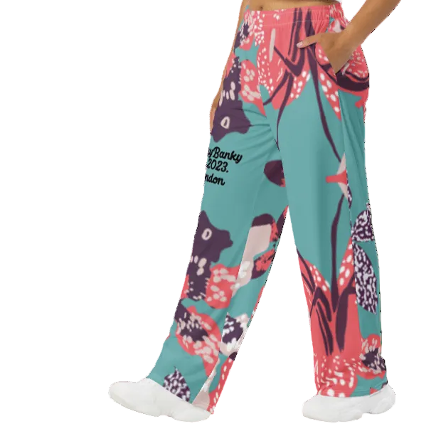 Model wearing the Chelsea Flow Joggers featuring  a tropical print and  heritage logo against a white background.