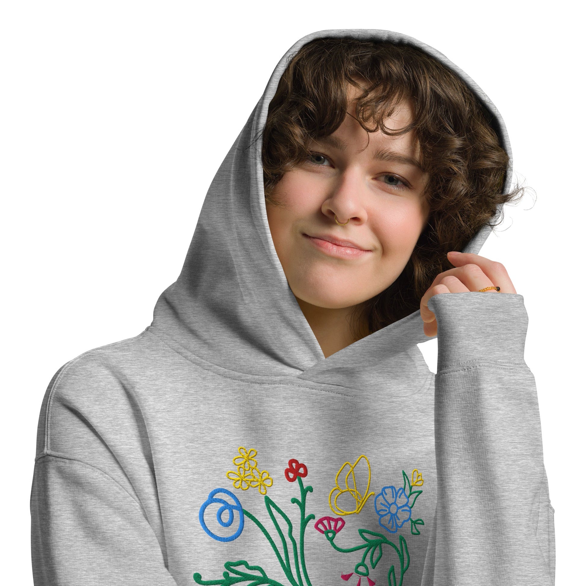A model wearing The Chelsea Garden Oversized Hoodie, showing the relaxed fit and the large, intricate floral arrangement embroidered across the chest.