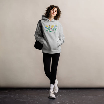 A model wearing The Chelsea Garden Oversized Hoodie, showing the relaxed fit and the large, intricate floral arrangement embroidered across the chest.