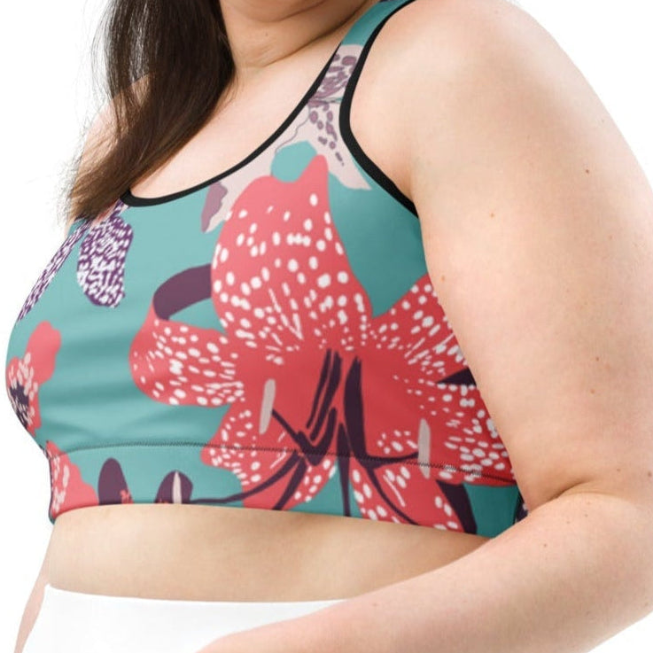 Model wearing the Chelsea Performance Bra high-compression performance sports bra featuring a vibrant tropical floral print in turquoise and pink.
