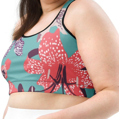 Model wearing the Chelsea Performance Bra high-compression performance sports bra featuring a vibrant tropical floral print in turquoise and pink.
