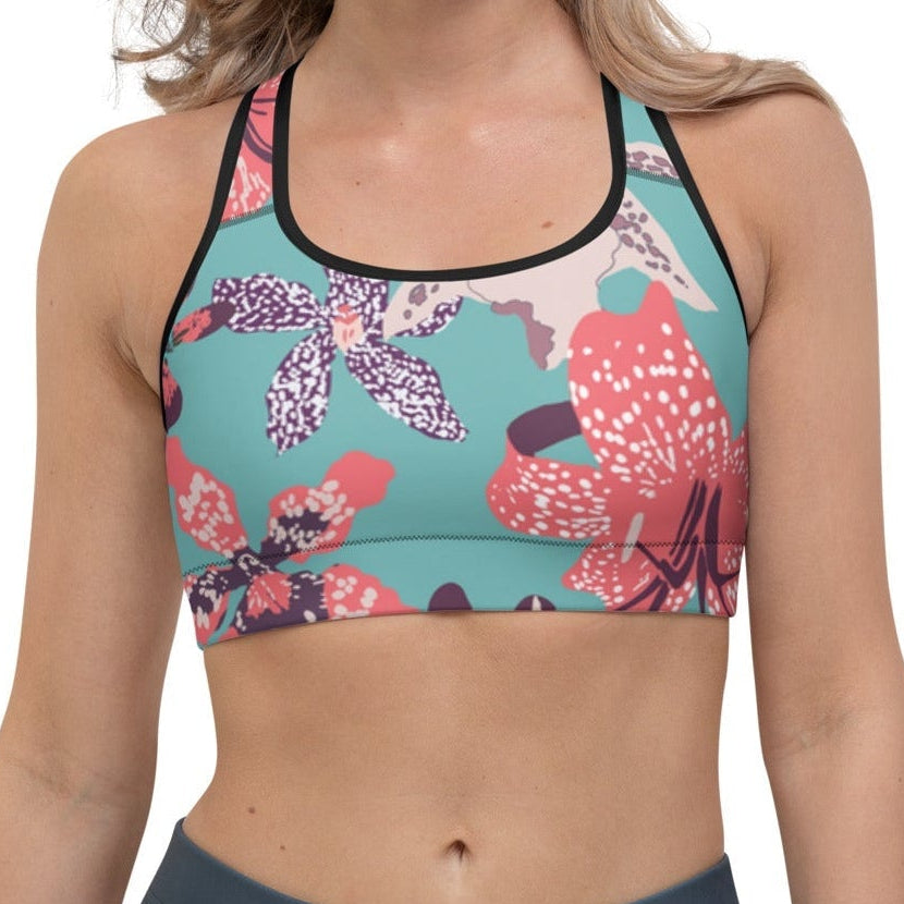Model wearing the Chelsea Performance Bra high-compression performance sports bra featuring a vibrant tropical floral print in turquoise and pink.