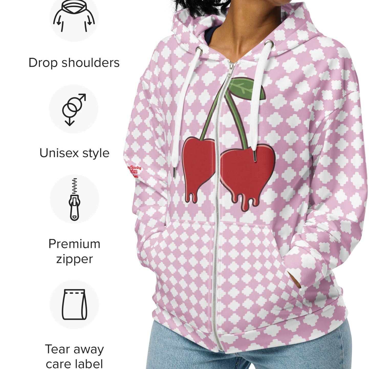 A BunnyBankY zip hoodie featuring a pink and white geometric clover pattern, a dripping heart-cherry graphic on the front, and 