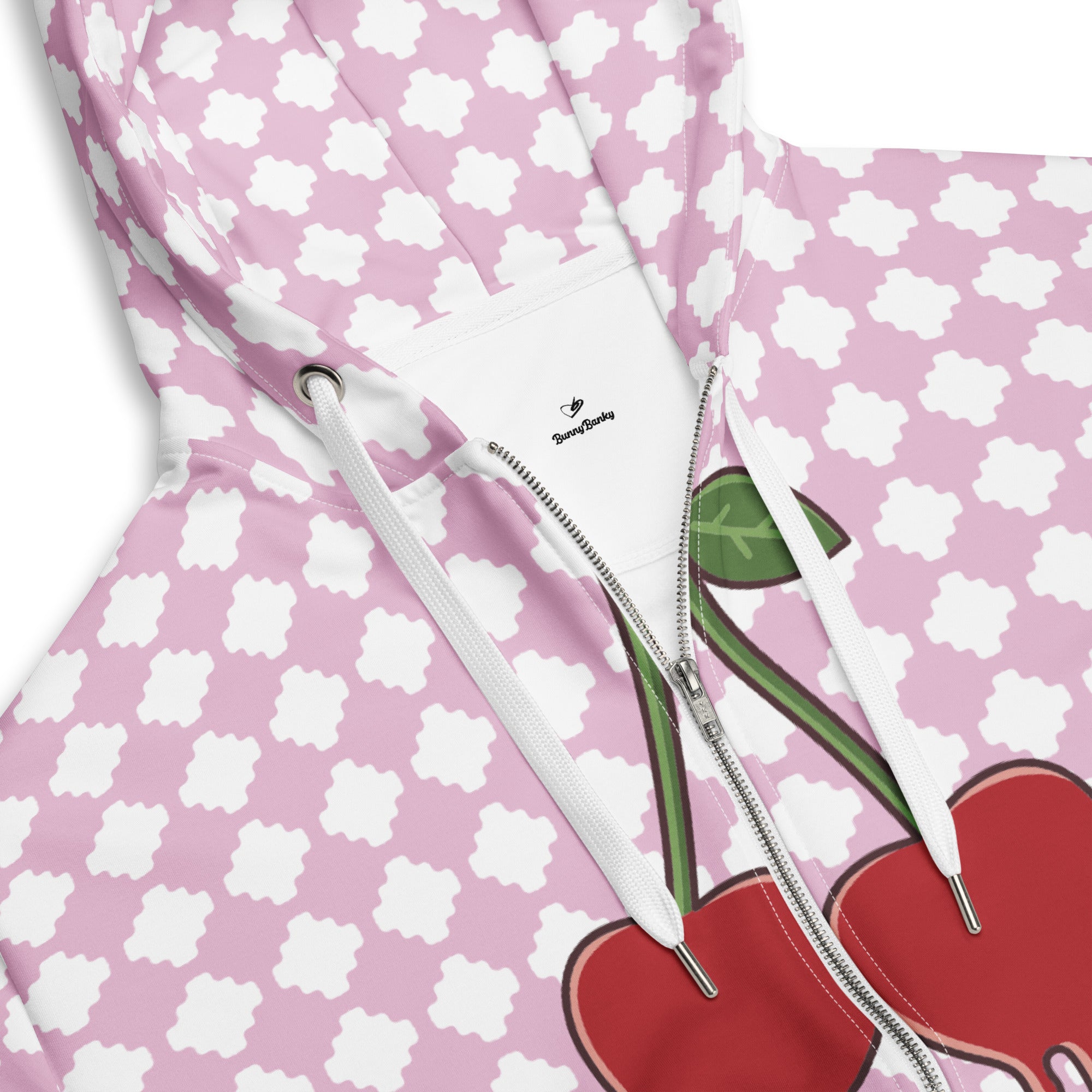 A BunnyBankY zip hoodie featuring a pink and white geometric clover pattern, a dripping heart-cherry graphic on the front, and 