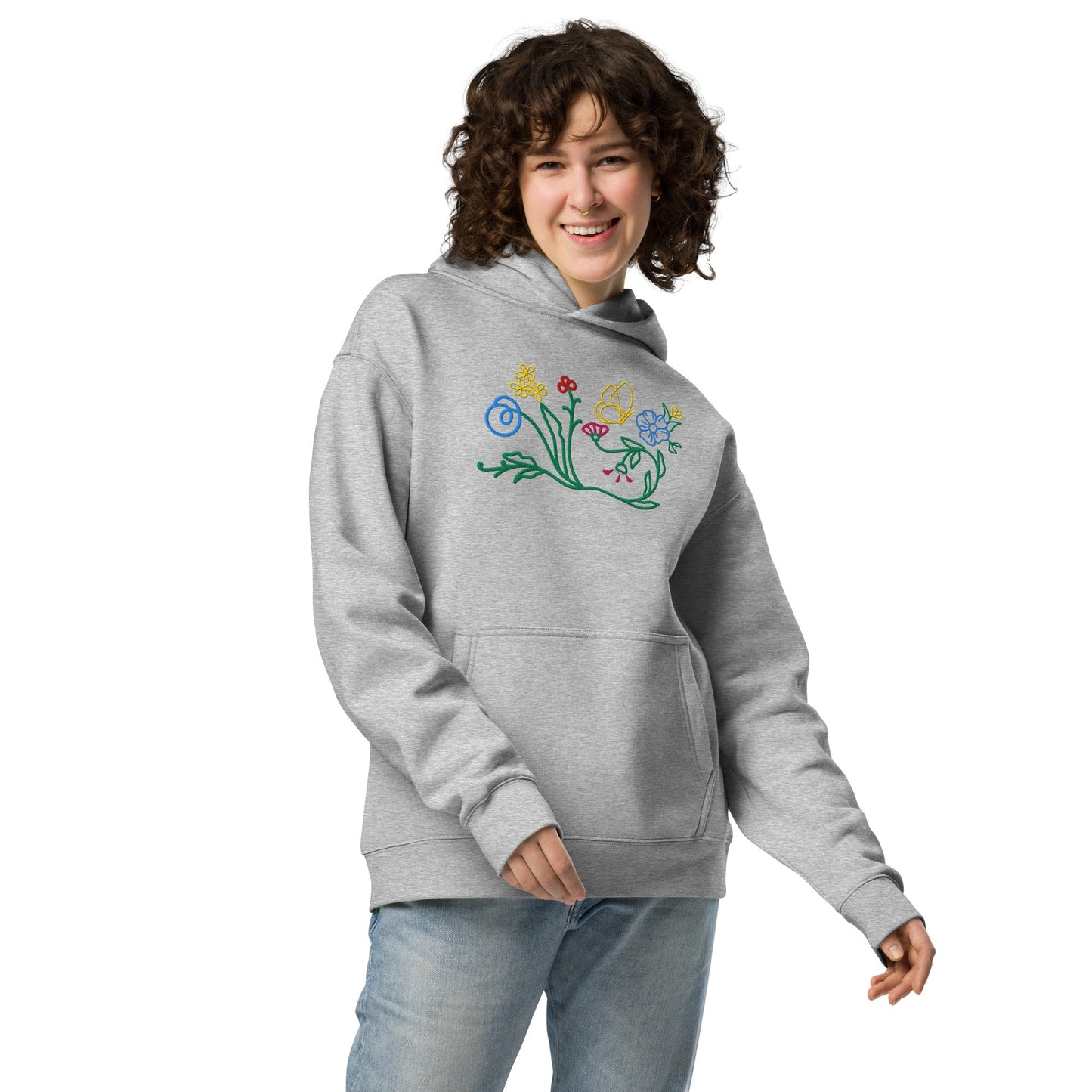 A model wearing The Chelsea Garden Oversized Hoodie, showing the relaxed fit and the large, intricate floral arrangement embroidered across the chest.