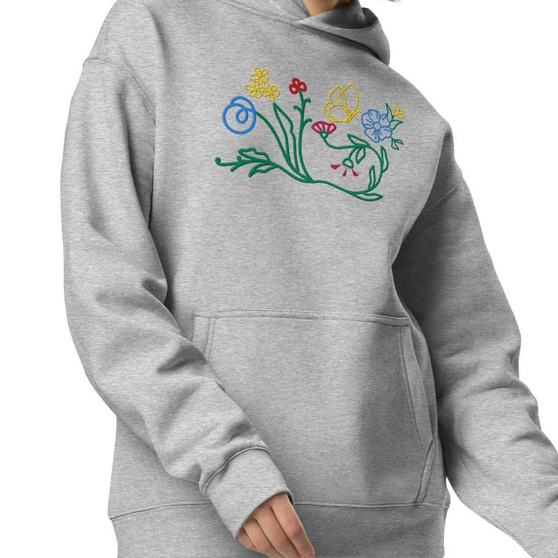 A model wearing The Chelsea Garden Oversized Hoodie, showing the relaxed fit and the large, intricate floral arrangement embroidered across the chest.