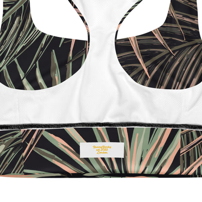 Close-up of the inside back of the chiswick longline performance bra.a sports bra showing a white mesh fabric, underwire cups with a black tropical palm leaf print, and a matching printed underband with a visible bunnybanky  interior label.