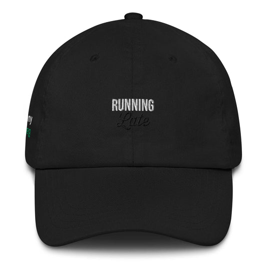 A close up of The Running Late Cap in pink showing the running late text embroidered in white and black