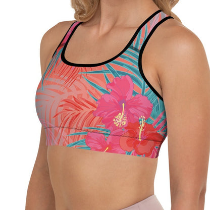 Close-up of a  model wearing the District Tropics Performance Bra. The image showcases the vibrant pink and blue floral pattern, the supportive racerback design, and the premium mesh lining details.