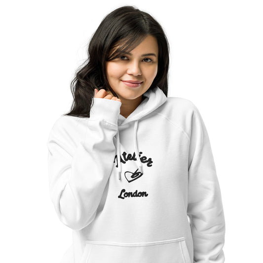 A model wearing The Atelier Hoodie showing the branded atelier heart logo