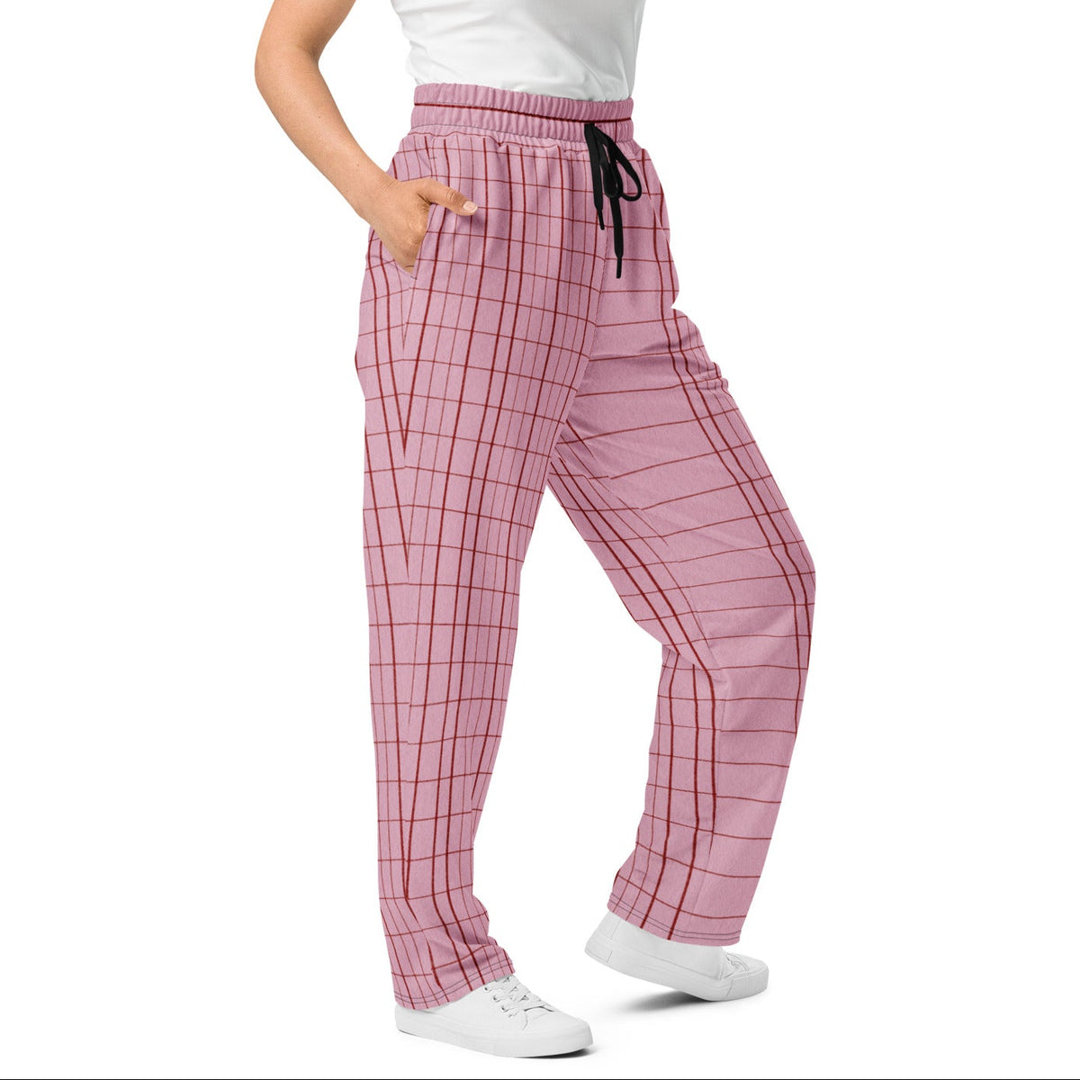 A woman modeling the edinburgh flow  joggers with a black drawstring, paired with a white tank top and white sneakers, against a plain white background.