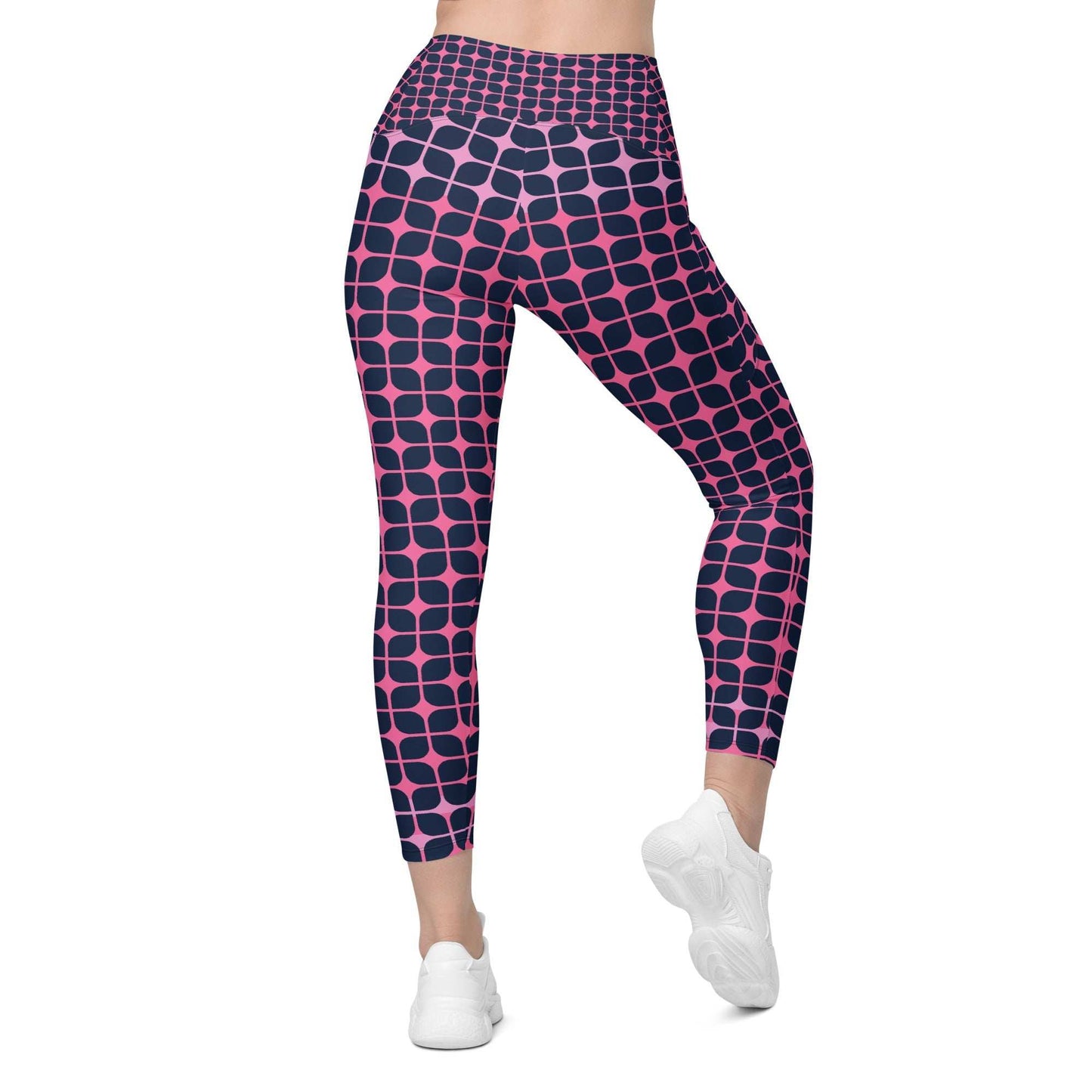 A model wearing The Embankment Sculpt Leggings, showing the sculpting fit and the navy and fuchsia geometric print.