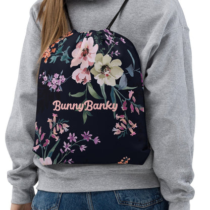 Model wearing the kew botanical bag featuring a  floral print on navy blue fabric.
