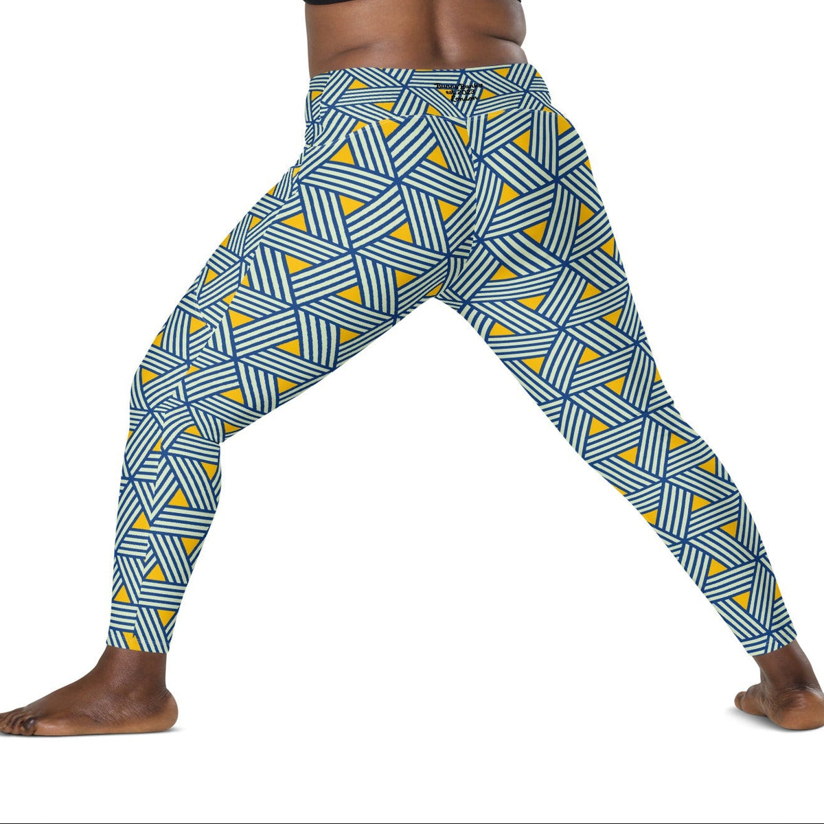 model wearing the Geneva Sculpt Leggings featuring a pattern of interweaved blue lines in yellow background.