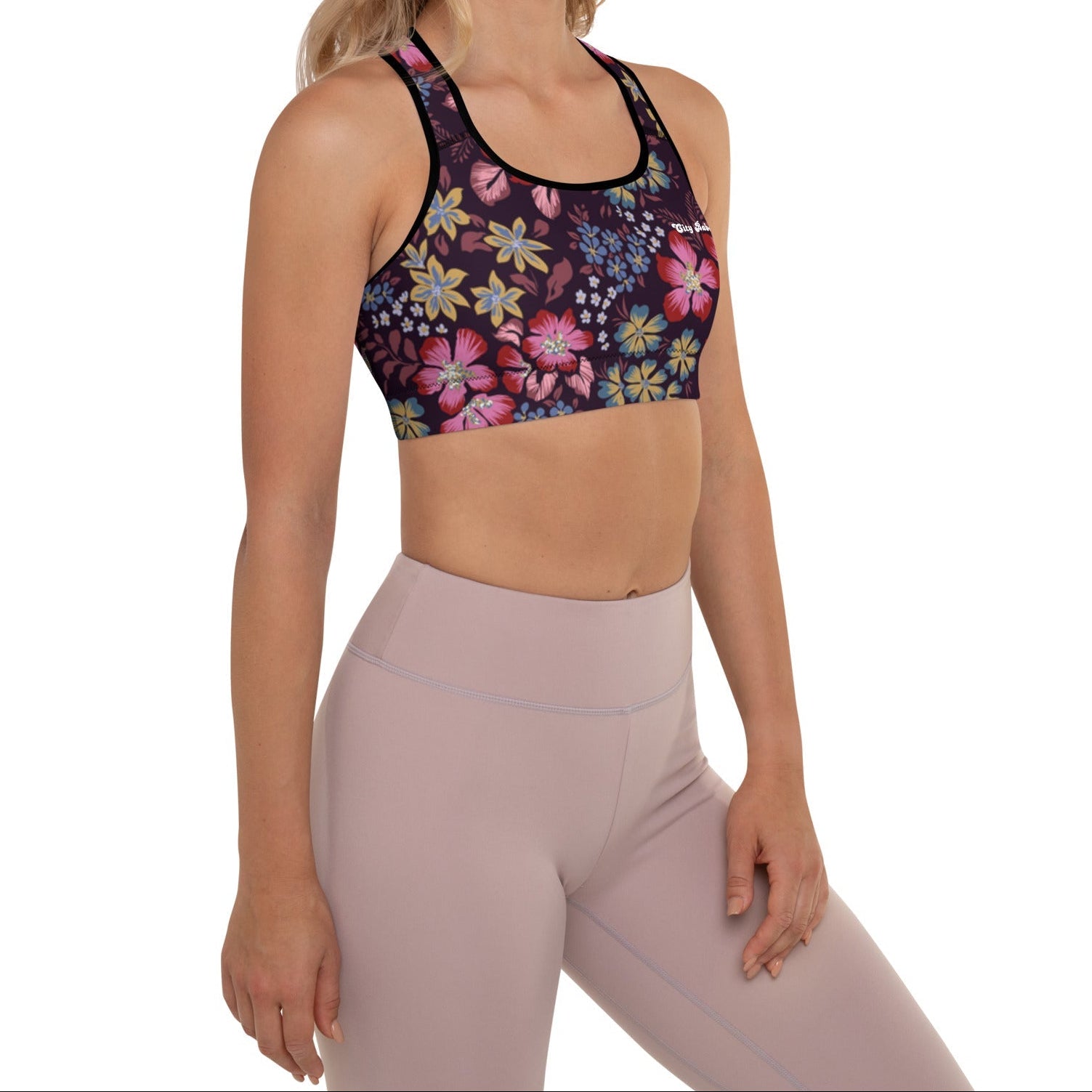 A model wearing the Green Park Performance Bra in blue, pink, yellow floral pattern on burgundy background