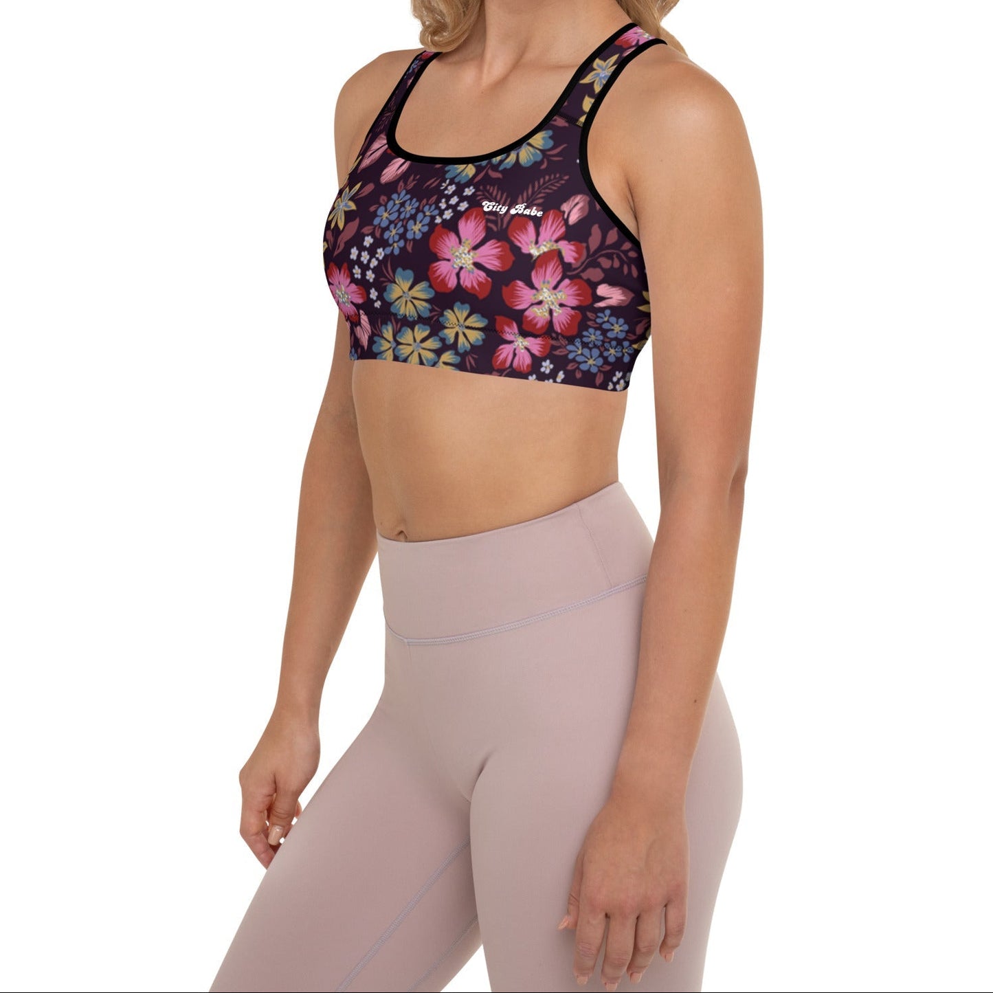 A model wearing the Green Park Performance Bra in blue, pink, yellow floral pattern on burgundy background