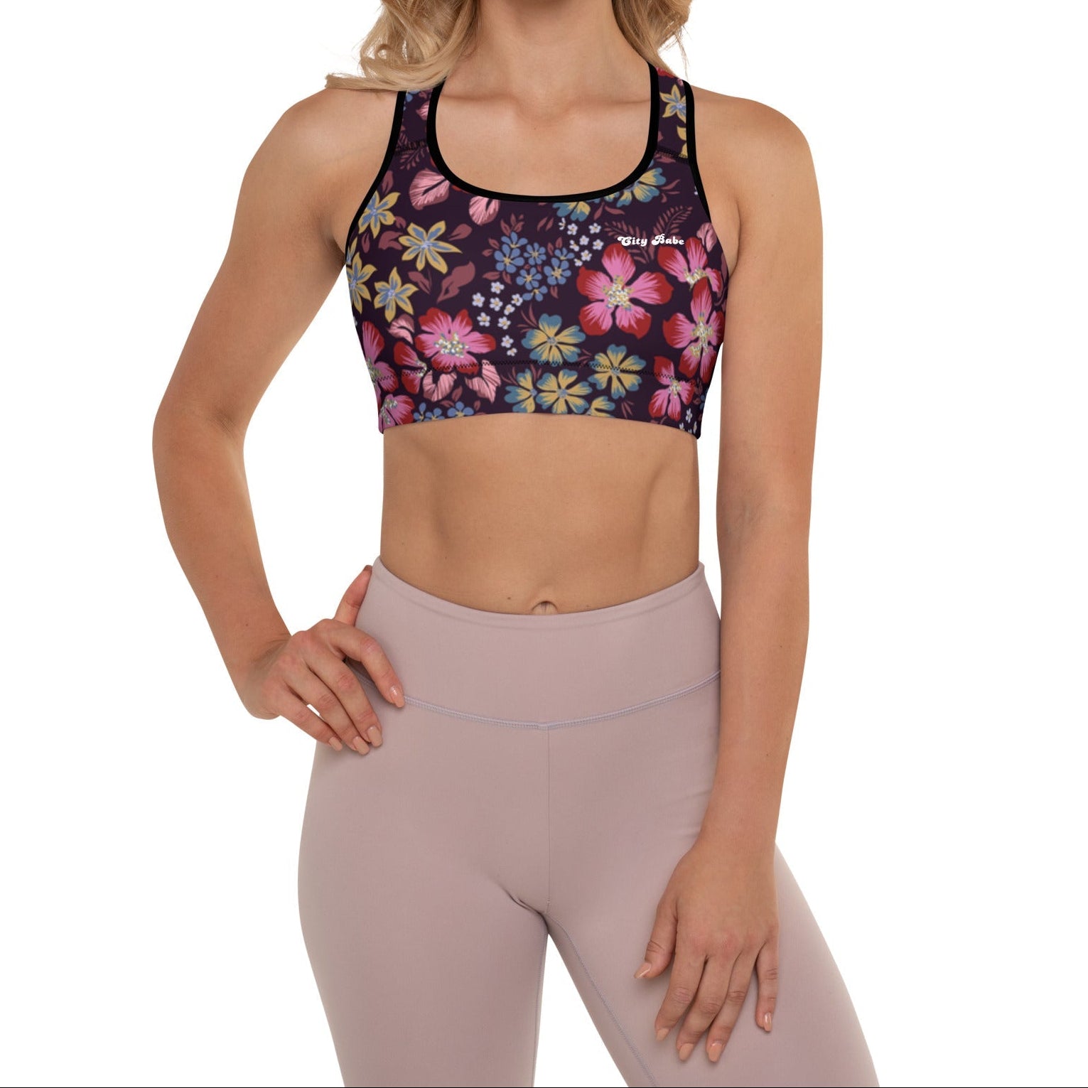 A model wearing the Green Park Performance Bra in blue, pink, yellow floral pattern on burgundy background