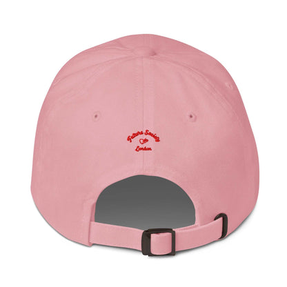 A close up of The Heritage Cap in pink showing the heriatage branded signature embroidered in red