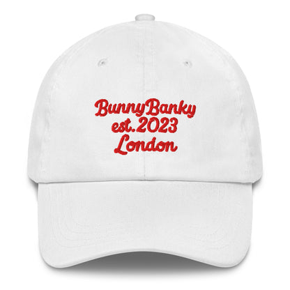 A close up of The Heritage Cap in white showing the heritage branded signature embroidered in red
