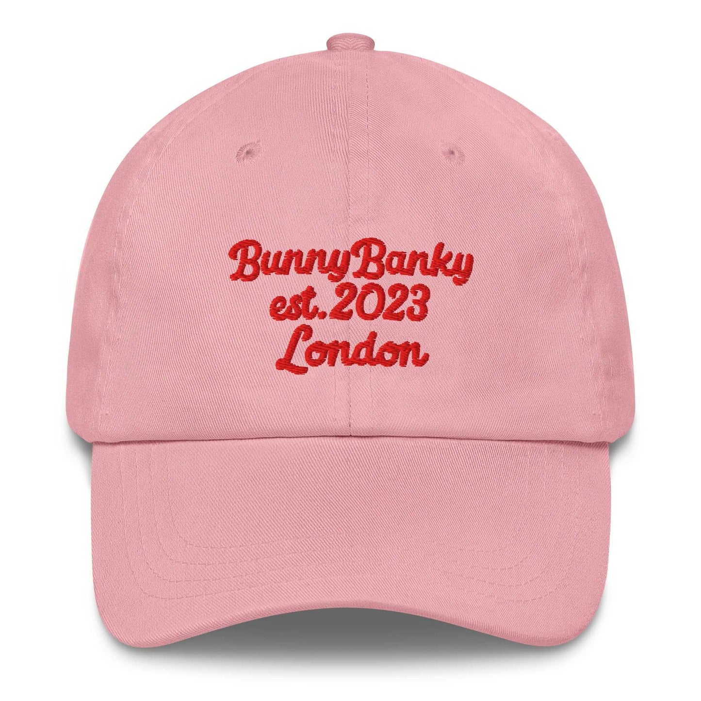 A close up of The Heritage Cap in pink showing the heritage branded signature embroidered in red