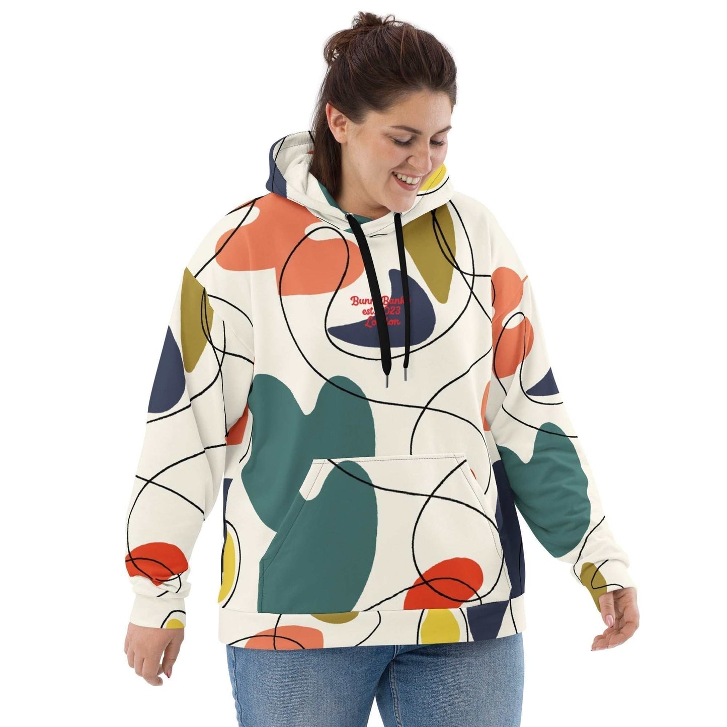 A model wearing The Joie de Vie Hoodie, showing the relaxed, oversized unisex fit and the vibrant Suprematist-inspired geometric print.