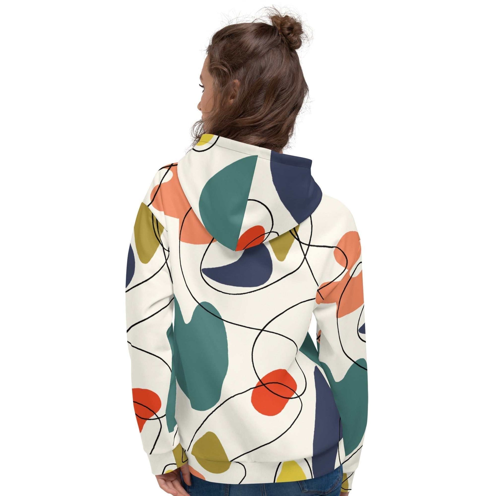 A model wearing The Joie de Vie Hoodie, showing the relaxed, oversized unisex fit and the vibrant Suprematist-inspired geometric print.