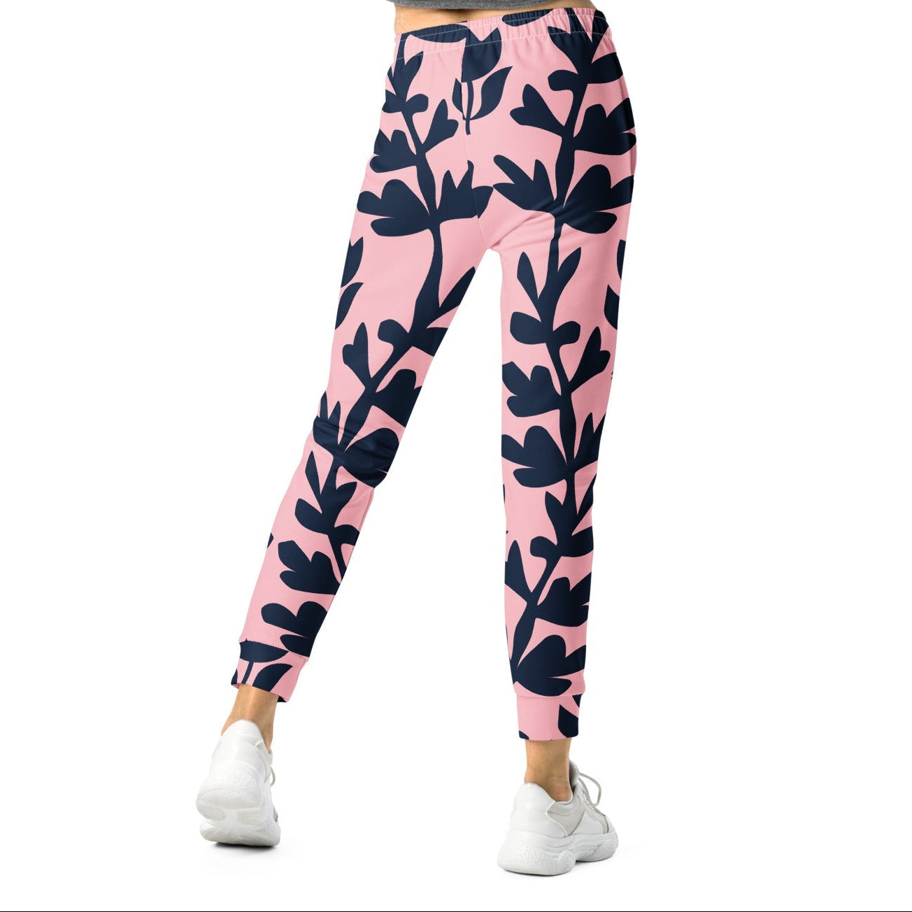 A model wearing The Kensington Glide Joggers, showing the slim fit and the bold, high-contrast pink and blue oversized floral print.