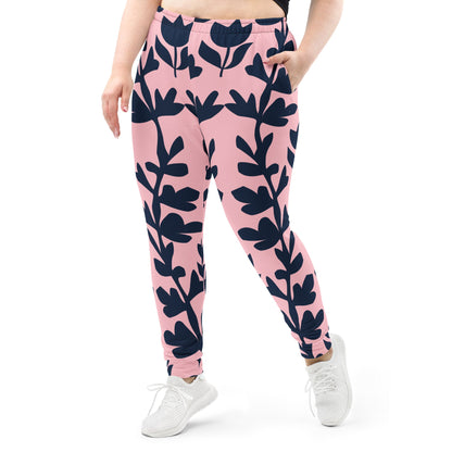 A model wearing The Kensington Glide Joggers, showing the slim fit and the bold, high-contrast pink and blue oversized floral print.