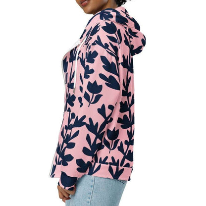 A model wearing The Kensington Zip Hoodie, showing the full-zip closure and the oversized pink and blue floral print across the recycled polyester fabric.