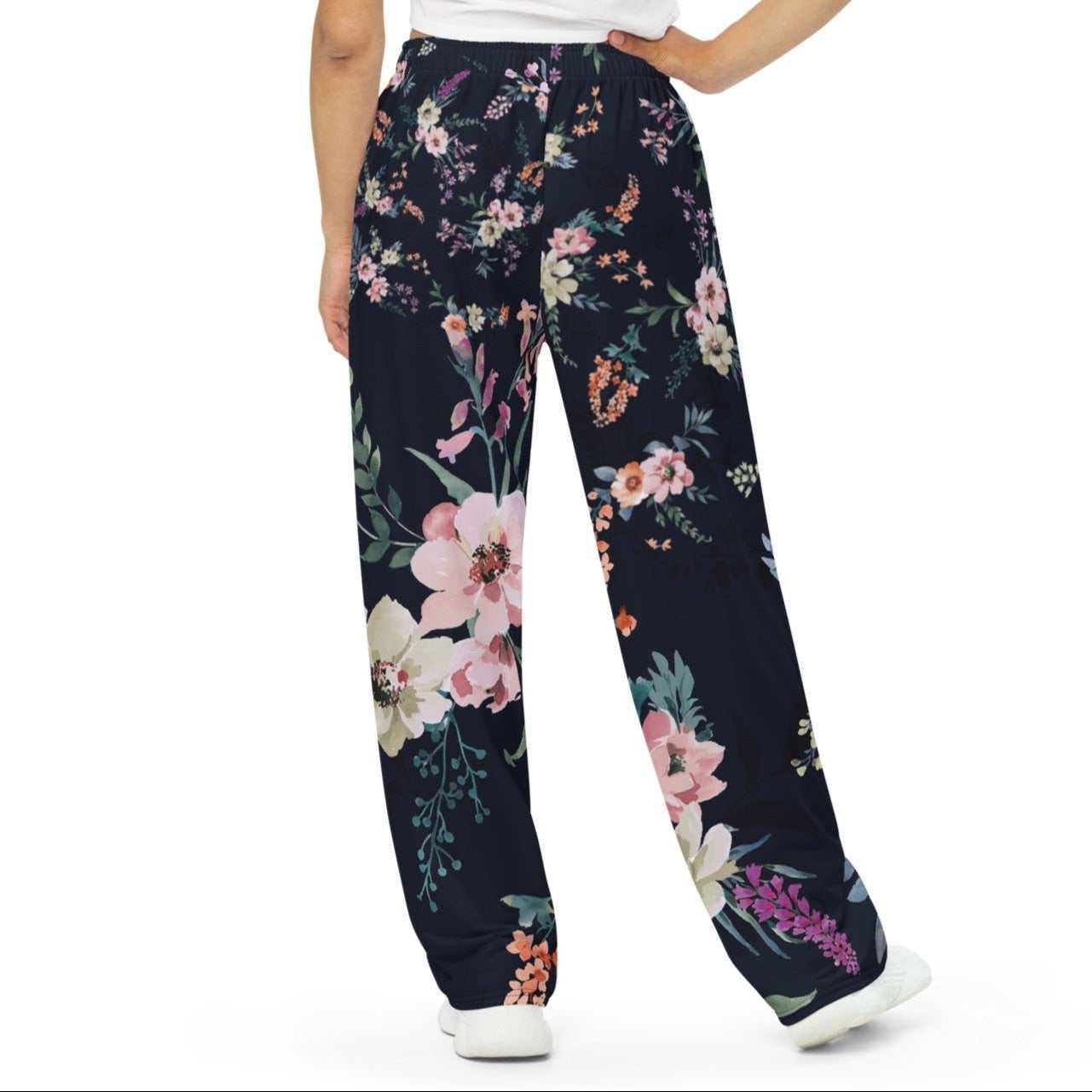 A model wearing the Kew Botanical Wide Leg Joggers. The image highlights the cohesive floral print across joggers, emphasizing the premium drape of the wide-leg cut.