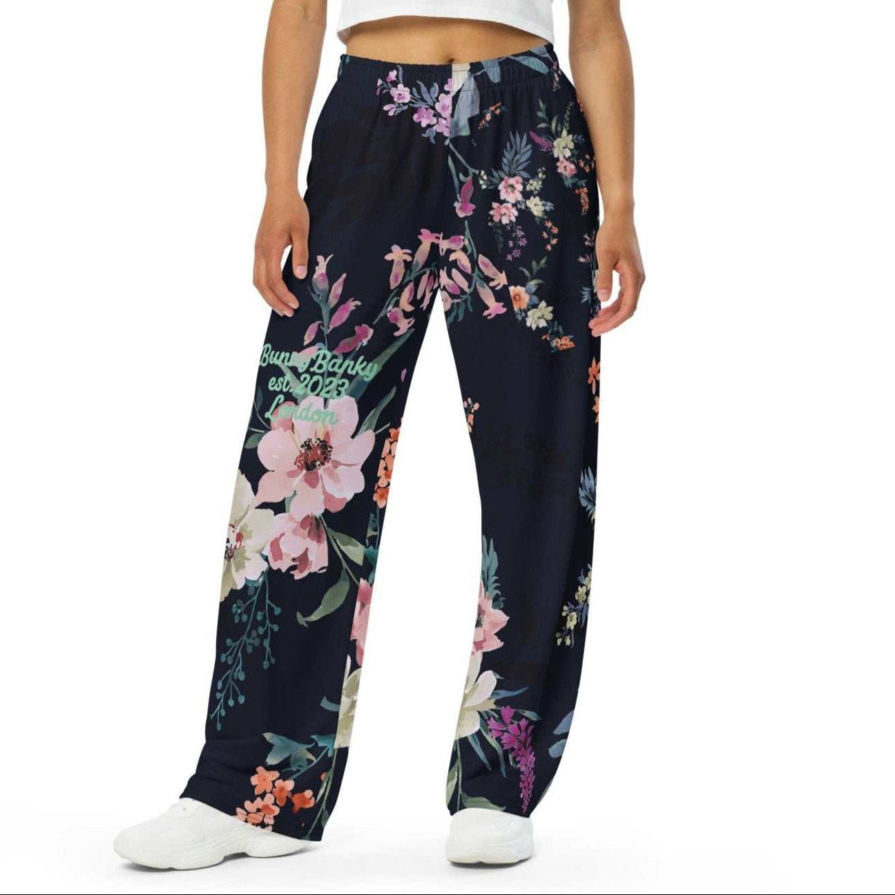 A model wearing the Kew Botanical Wide Leg Joggers. The image highlights the cohesive floral print across joggers, emphasizing the premium drape of the wide-leg cut.